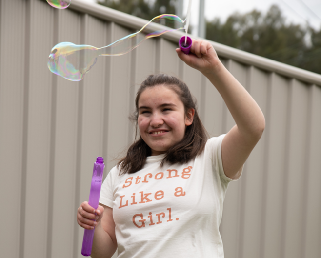 Northcott customer Sabah smiling while playing with bubbles