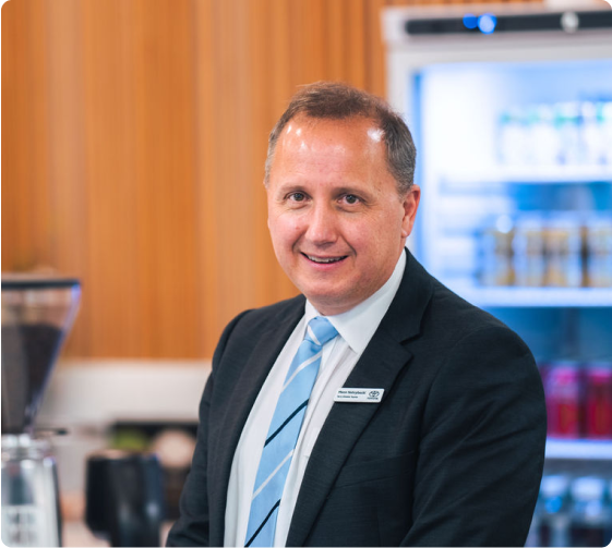 Meon Nehrybecki, Principal Dealer at Terry Shields Toyota in Parramatta in a suit and tie, smiling at the camera